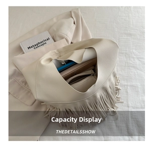 Detail of spacious cream leather tote bag interior with tassel and laptop storage
