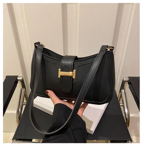 Détail du sac porté épaule noir en demi-lune avec boucle métallique dorée en forme de H