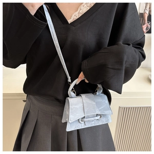 Detailed view of light blue marble mini bag with hourglass silhouette on model