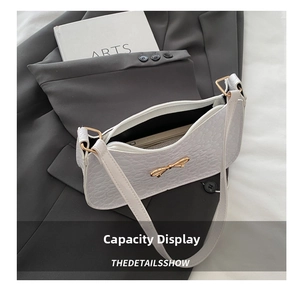 Detail showing white embossed bow handbag interior capacity fitting a smartphone