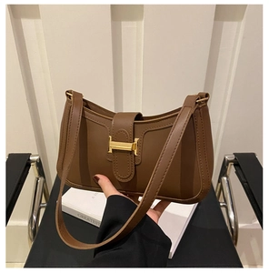 Gros plan sur le sac baguette en cuir vintage marron avec une boucle dorée en forme de H