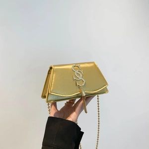 Mini sac bandoulière doré avec logo S métallique et franges sur fond minimaliste chic