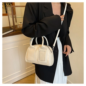 Chic cream white Boston bag featuring square patches and polished faux leather texture
