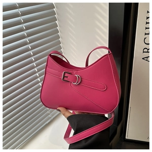 Detail of hot pink shoulder bag featuring decorative silver buckle strap and leather texture