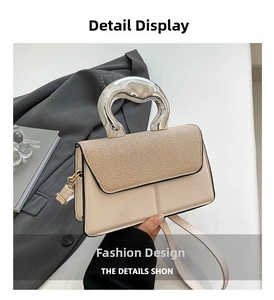 Detail of contrast stitch handbag featuring a textured lid and unique silver metal handle