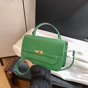 Green leather tote bag with gold swivel lock closure and shoulder strap in minimal style