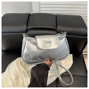 Close-up of metallic silver PU bag with a decorative metal bow and elegant stitching