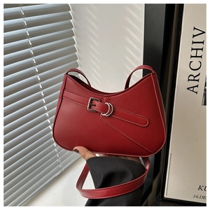 Detail of a vintage dark red leather underarm bag with decorative belt and silver buckle