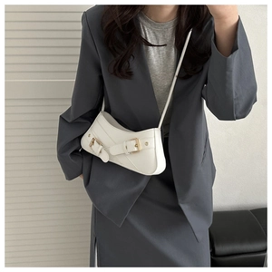 Detail view of white crescent bag with golden buckles and fine diagonal stitching details