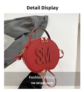 Detailed close-up of red circular crossbody bag with SM logo and gold metal zippers
