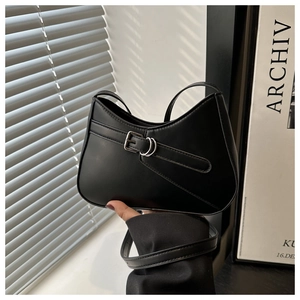 Detail of minimalist black crescent handbag with metallic buckle and shadow effect