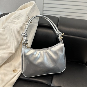 Minimalist silver metallic shoulder bag with pleated texture and knotted strap detail