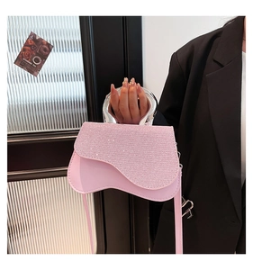 Detail of pink crossbody bag featuring a rhinestone flap and elegant silver round handle