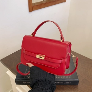 Classic bright red leather handbag with gold metal lock and detachable shoulder strap