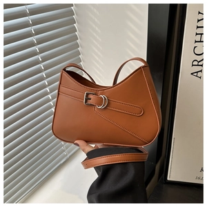 Detailed shot of brown crescent underarm bag with silver buckle and smooth faux leather