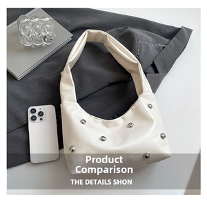 Detail of white leather hobo bag with silver metallic studs on grey suit background