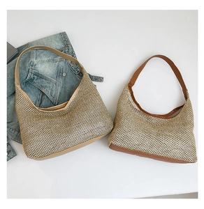 Detail of woven straw tote bags with faux leather straps in khaki and brown finishes