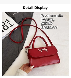 Close-up of a red glossy patent leather square bag with a silver bow metal decoration