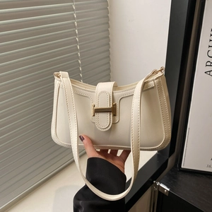 Sac croissant chic en cuir blanc crème avec boucle H dorée présenté dans un cadre élégant