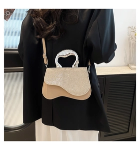 Detail of glitter champagne flap and irregular silver handle on beige leather crossbody bag
