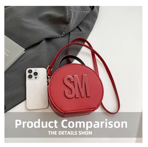 Close-up of red circular crossbody bag with SM logo and smartphone for size reference