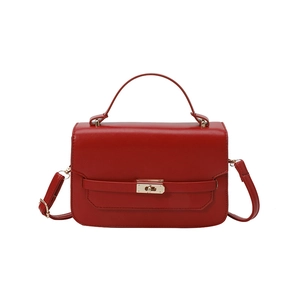 Minimalist red leather crossbody bag with top handle and gold metal twist lock