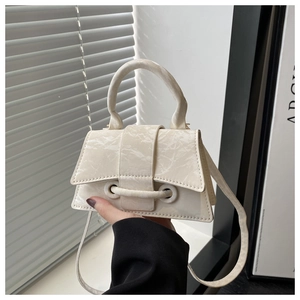 Detailed macro view of the minimalist beige marble-textured mini trapezoid handbag