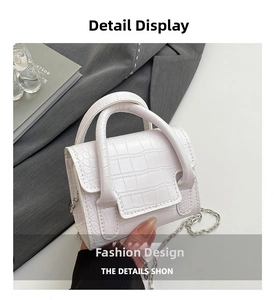 Detail of white crocodile texture mini bag with silver chain strap and curved handles