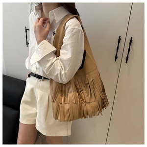 Detail of khaki tassel tote bag showing the soft lychee grain texture and long fringes