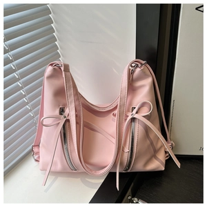 Gros plan du sac cabas rose avec des nœuds ruban et des fermetures éclair argentées