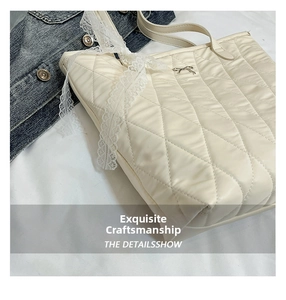 Détail du cabas matelassé blanc avec nœud argenté et ruban en dentelle décoratif