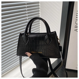 Detail of black crocodile texture handbag with gold Fashion and Bags logo text