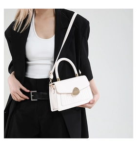 Détail du sac blanc à texture crocodile avec boucle magnétique dorée élégante et chic