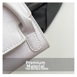 Macro view of white faux crocodile leather texture and fine stitching on the small square bag