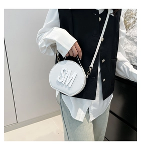 Detail of white round crossbody bag with 3D SM letter design and golden hardware