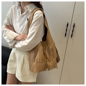 Close-up of vintage khaki tote bag featuring double-layer fringes and lychee texture