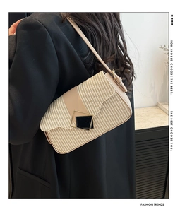 Gros plan du sac porté épaule tissé beige avec boucle géométrique et bandoulière en cuir