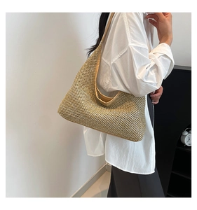 Golden woven hobo bag detail with metallic shimmer finish on a fashion model