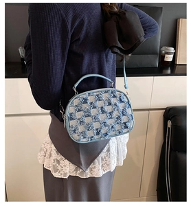 Detail der hellblauen karierten Jeans-Schultertasche mit Fransen und Handgriff