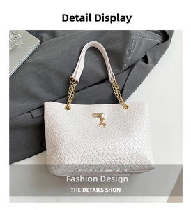 Close-up of white woven leather tote featuring gold deer charm and elegant chain strap