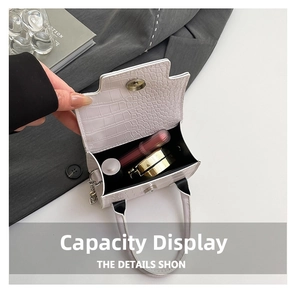 Detail view of white crocodile pattern bag showing capacity for lipstick and compact