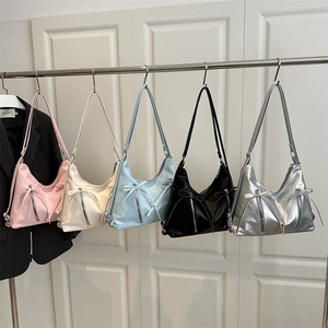 Sacs portés épaule Hobo en cinq couleurs avec nœuds et zips suspendus sur un portant