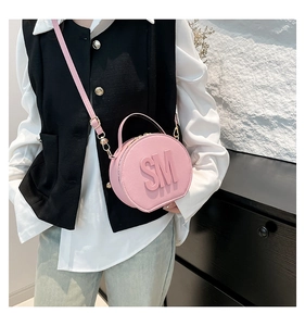 Detail of pink circular crossbody bag with SM embossed letters and gold hardware