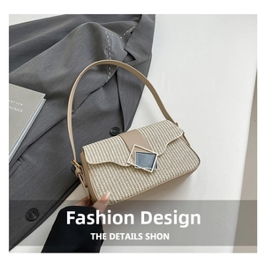 Gros plan détaillé du sac porté épaule en paille avec bordure en cuir beige et fermoir métal