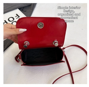 Interior view showing black fabric lining and silver magnetic buckle of the red bag