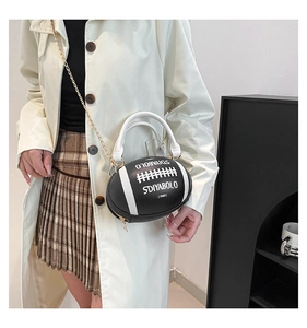 Detail of rugby-shaped handbag with SDIYABOLO print and gold chain strap on trench coat