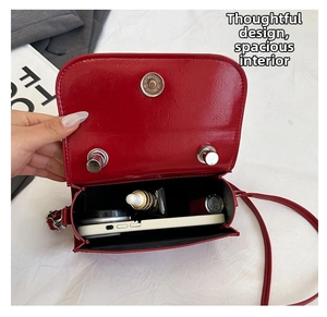 Detailed interior view of red leather crossbody bag showing compartments and magnetic closure