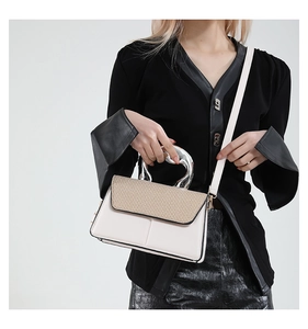 Detail of contrast stitch handbag with silver irregular metal handle and shoulder strap
