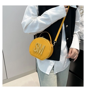 Detailed view of yellow grain leather D-shape handbag with large SM metal lettering