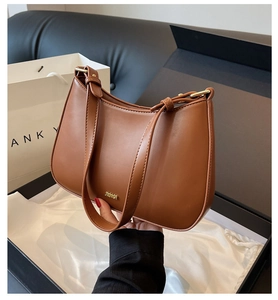 Brown leather baguette bag with gold logo presented in an elegant black gift box